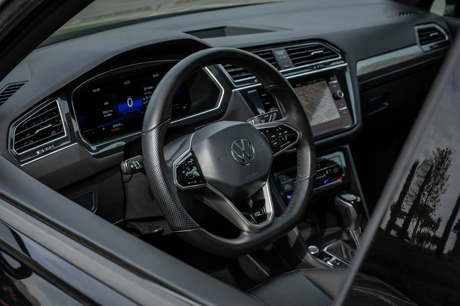 Interior de um carro moderno, com painel digital e navegação ligada na tela central